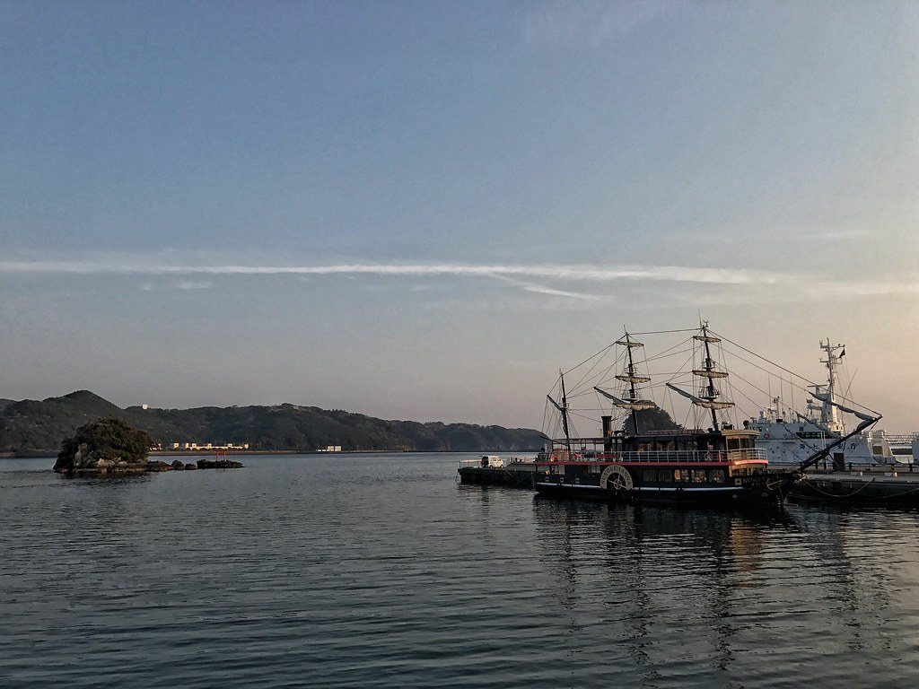 Shimoda harbour at dusk with a replica black ship moored at the quay