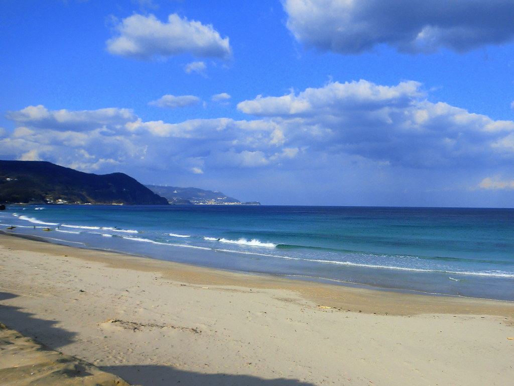 Wide white-sand beach with blue sea and clouds at Shirahama Ohama