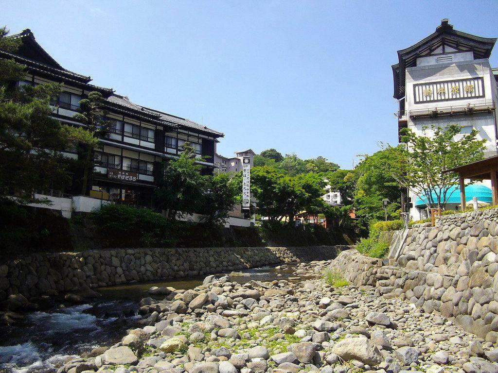 Ryokan and a lookout tower beside the rocky Katsura River in Shuzenji Onsen